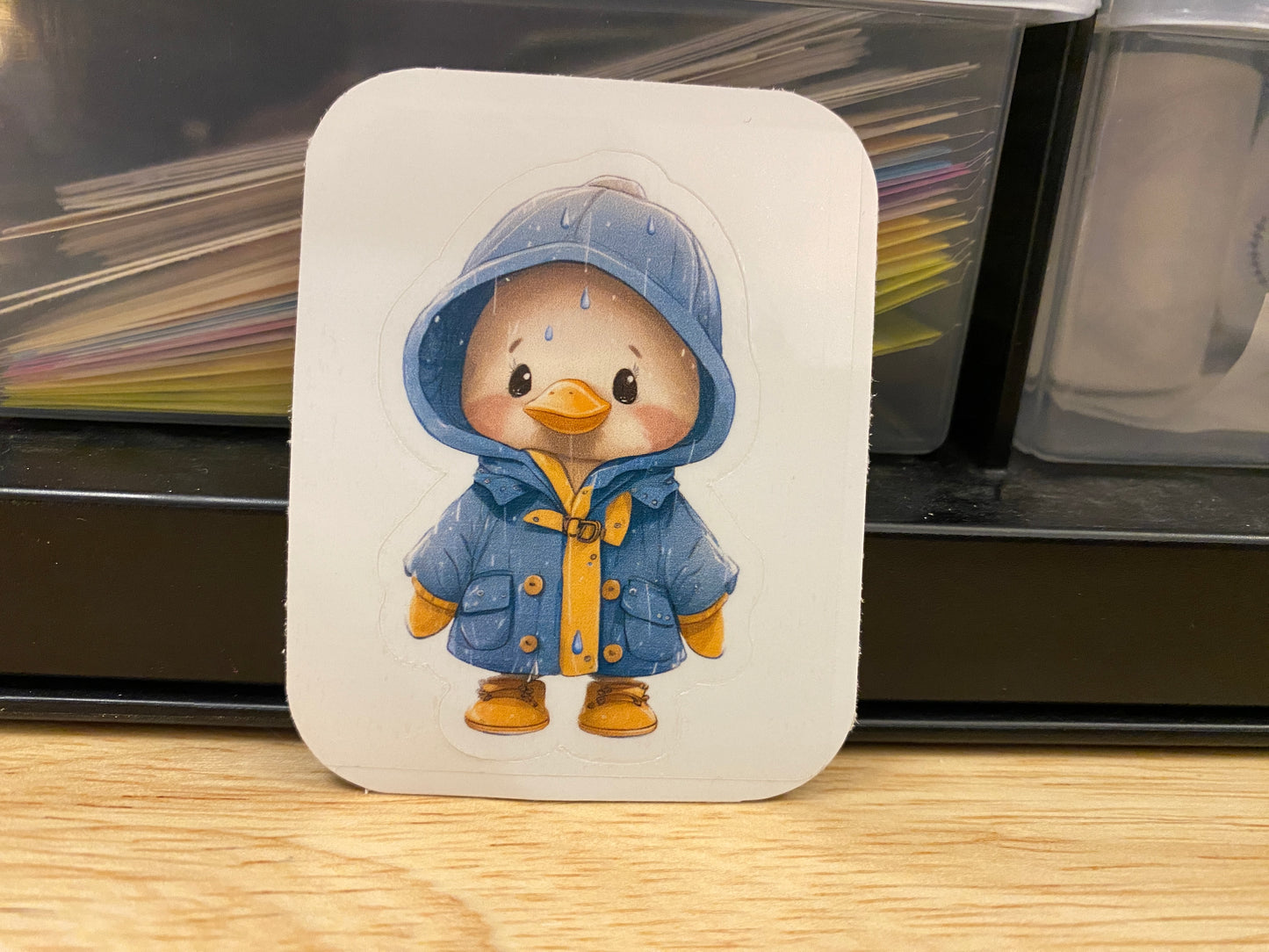 Yellow duck in blue rain jacket sticker